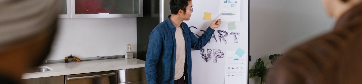 man in blue jacket looking at white board 7413916